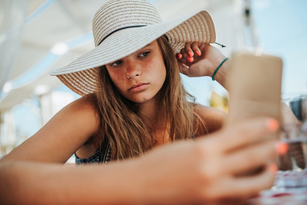 Young Woman Looks at Skin Outside in Summer