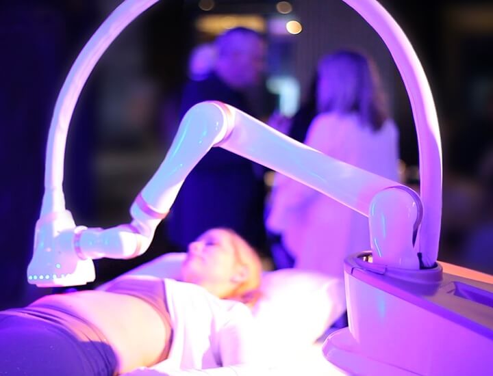 patient lying on table with EON white robotic arm over abdomen
