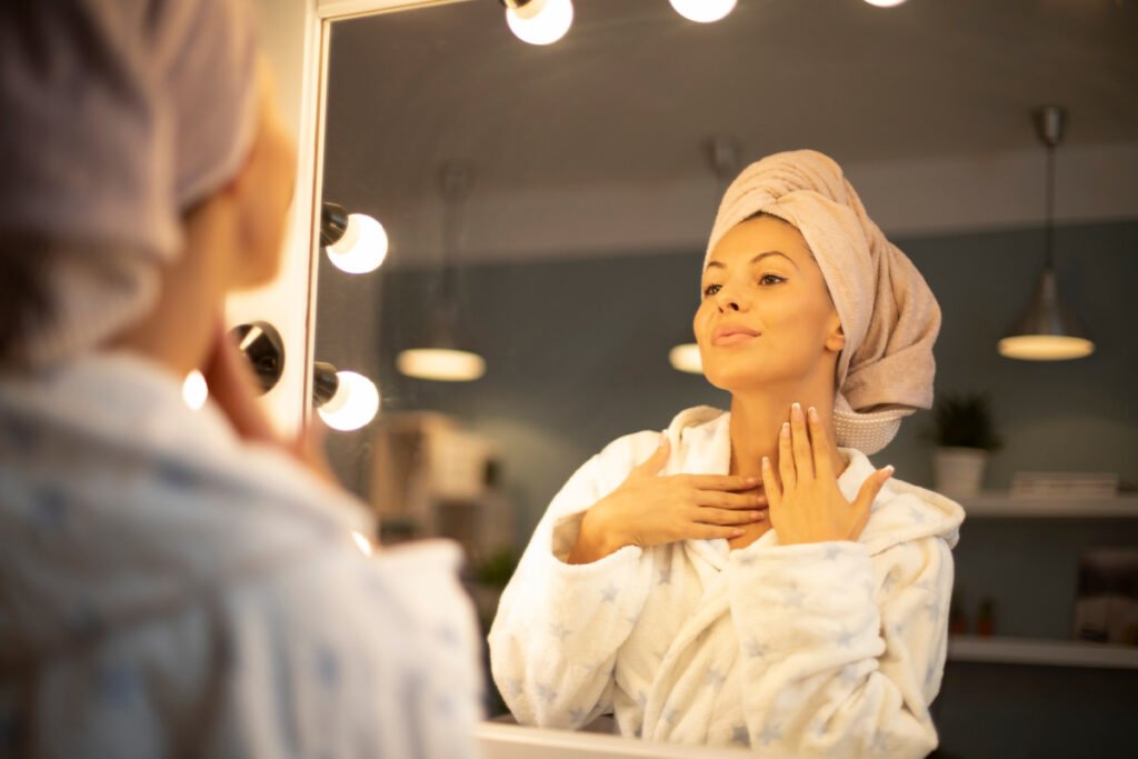 Woman applies skincare to neck after a neck treatment 