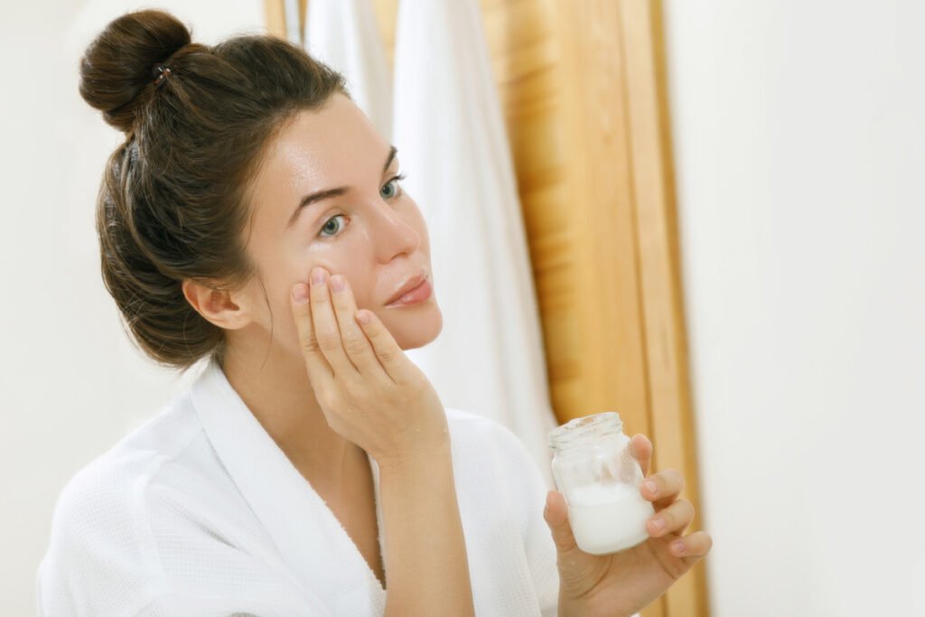 Woman applying vaseline to skin before bed following slugging skincare trend