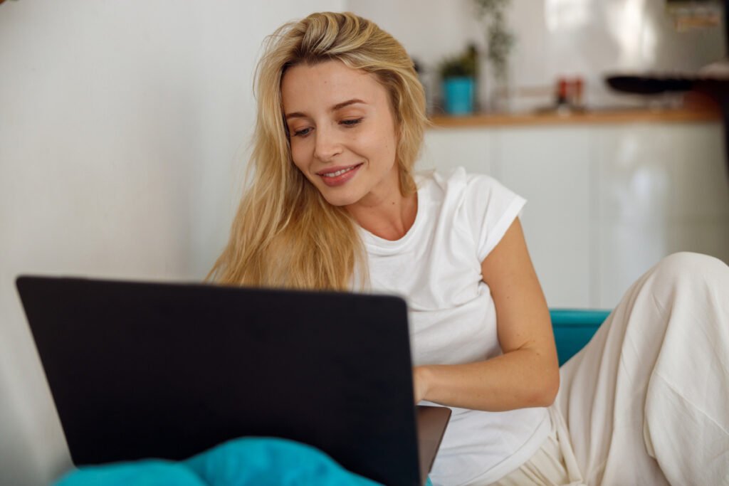 Woman smiling looking down at her laptop screen