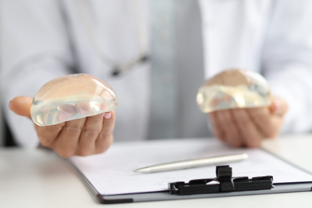 Plastic surgeon holding silicone breast implants during a breast augmentation consultation