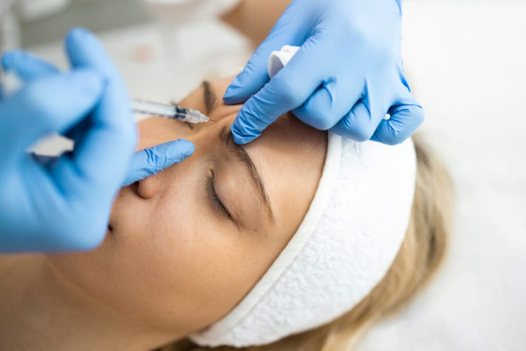 Woman getting Botox injections on glabellar lines in forehead